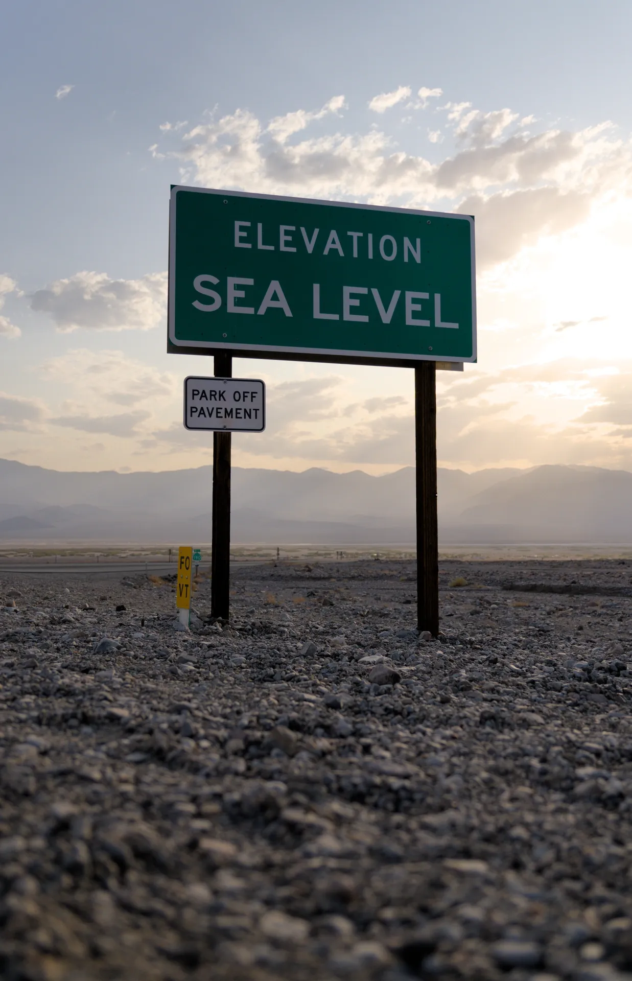 Sea level elevation sign at sunset.