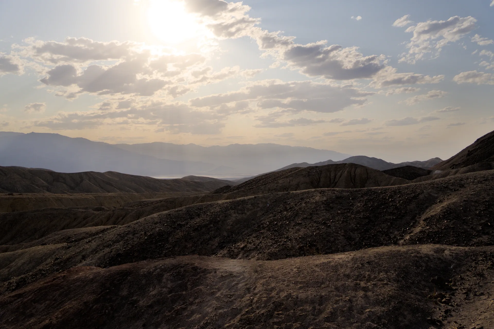 Sunrays over rolling badlands.