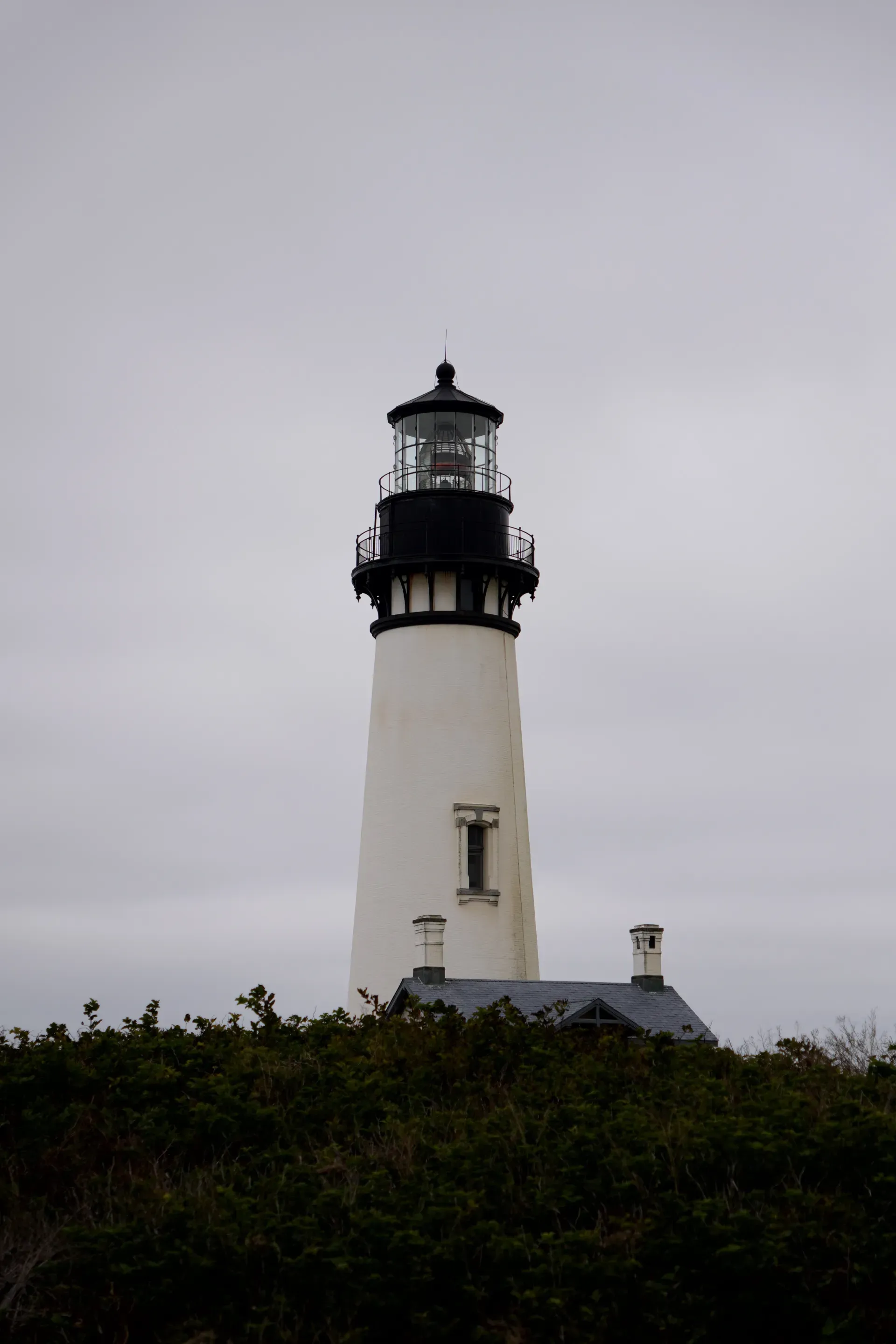 Yaquina Head Lighthouse under overcast sky.